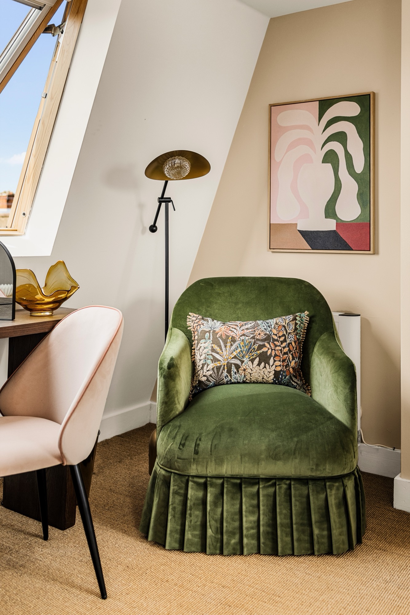 Interior detail photography in a Chelsea loft: green velvet armchair under a skylight with modern art