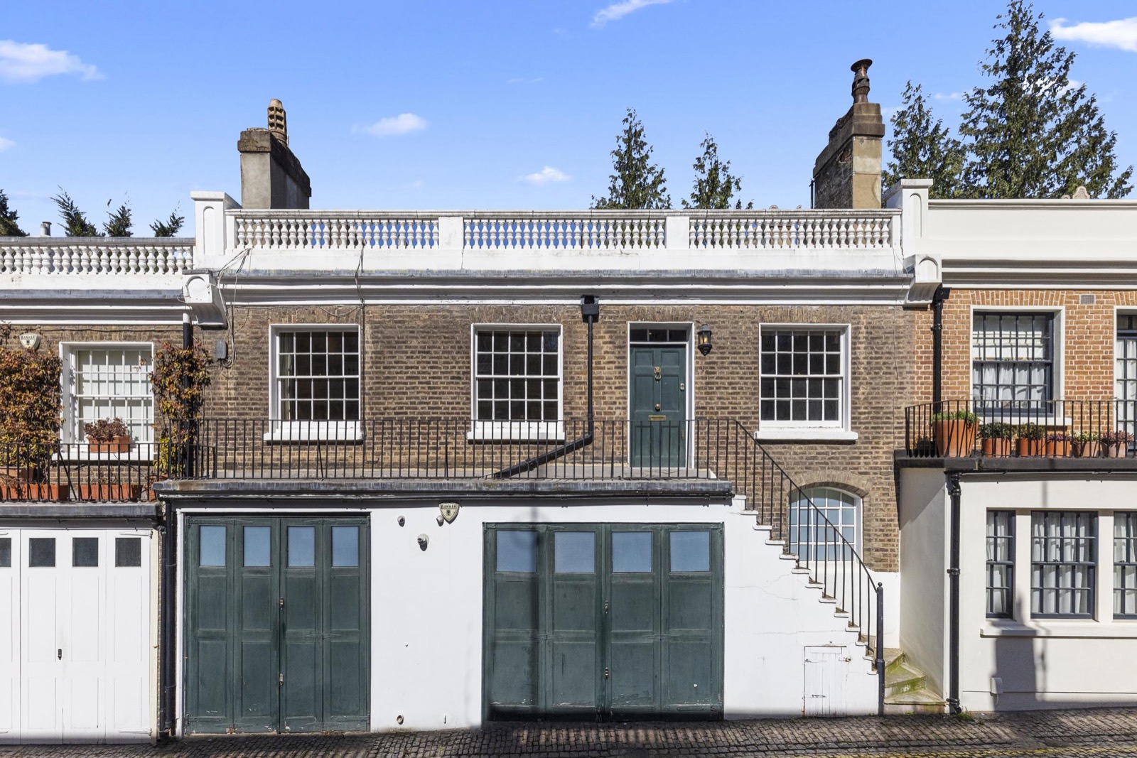 Exterior photography of a Mayfair mews: painted stable doors, brick facades and balustraded roofline