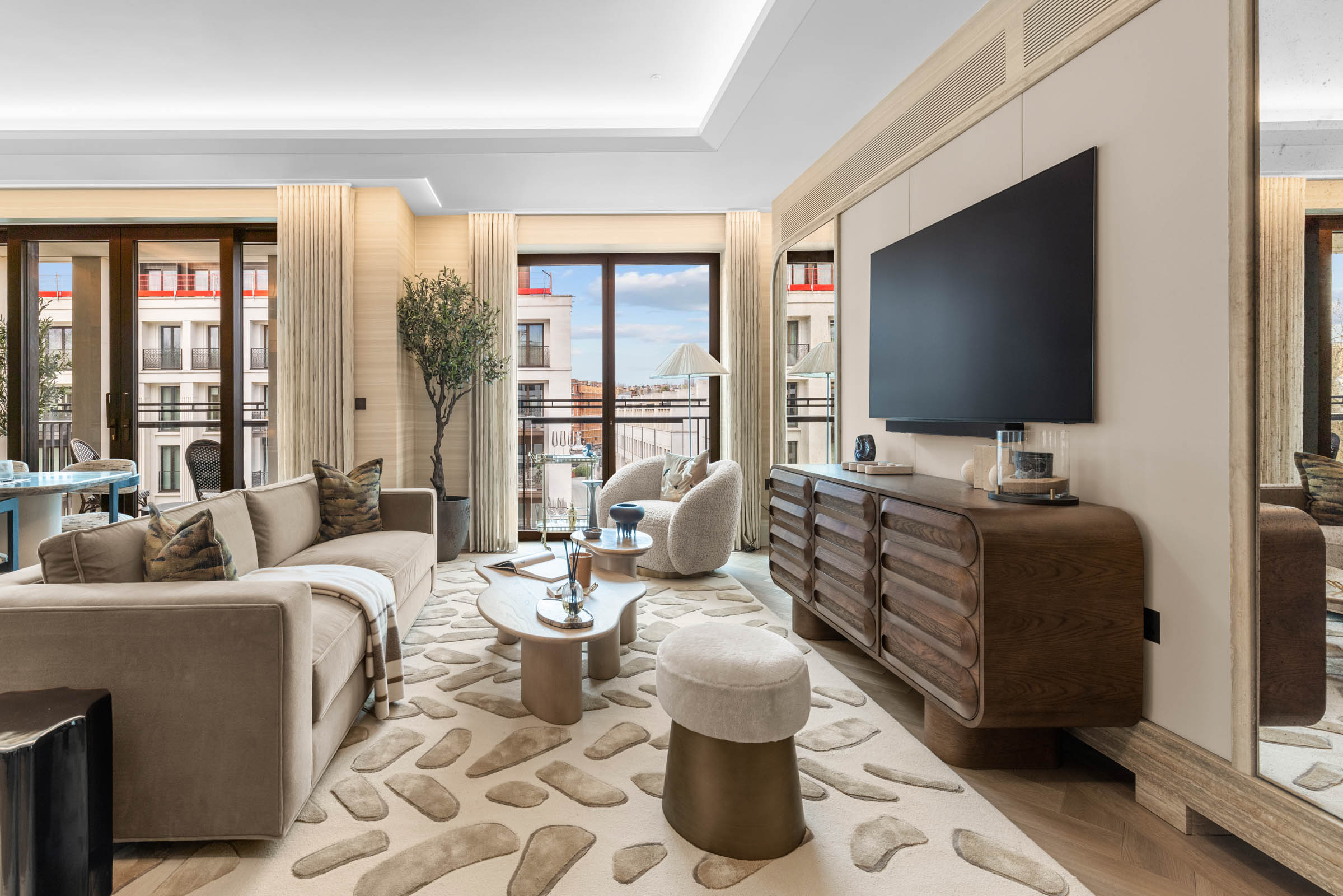 Modern living room photography in Mayfair: open-plan lounge with balcony doors and sculptural rug