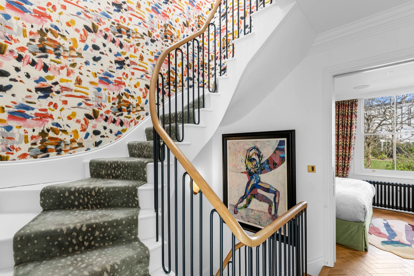 Staircase photography in a Holland Park house: hand-painted mural wall, brass handrail and stair runner