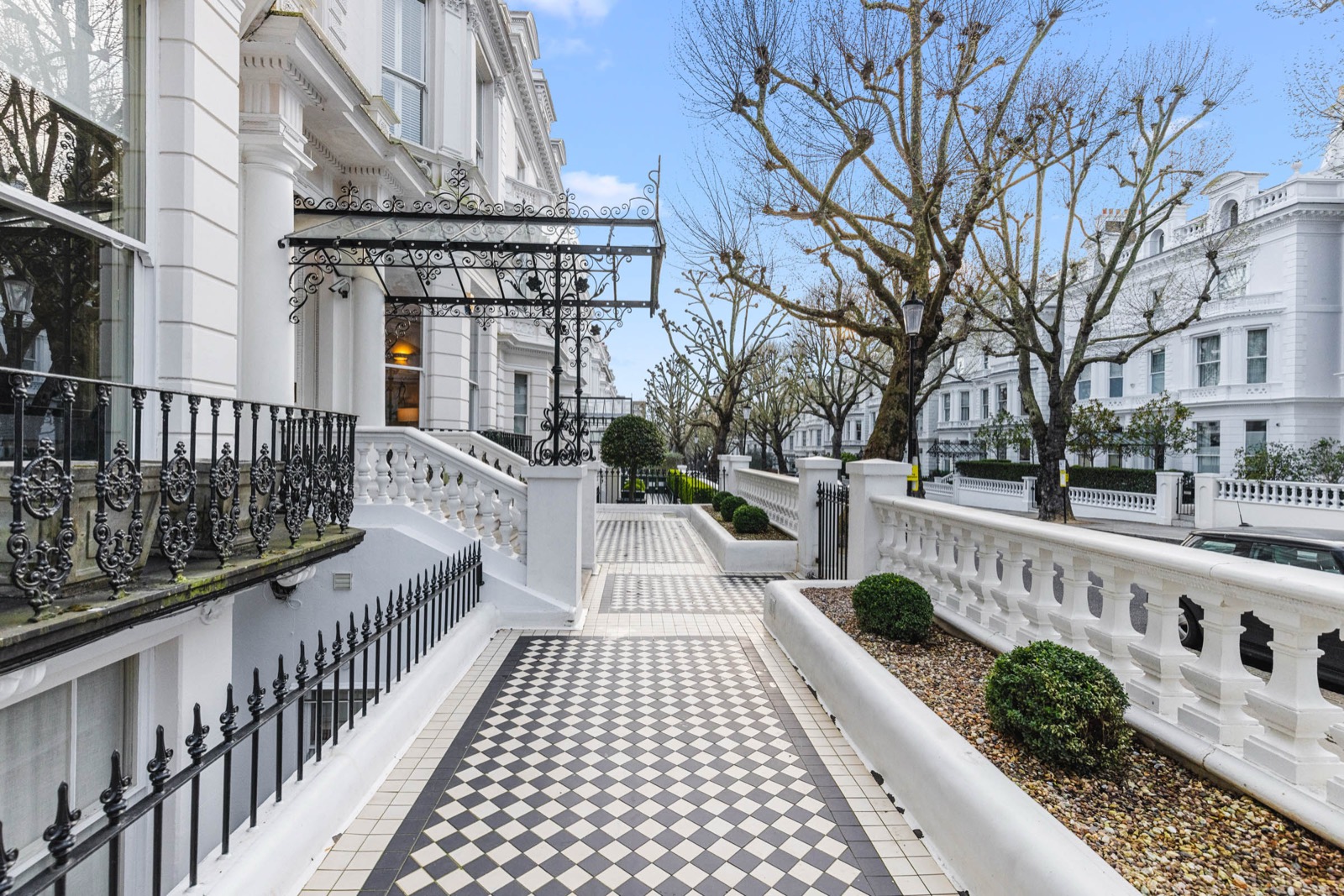 Exterior photography of white stucco terraced houses with chequerboard paths in Holland Park, London