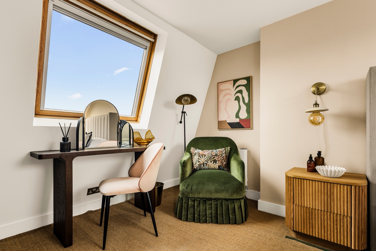Styled bedroom photography in a Notting Hill loft: dormer window, dressing table and green velvet armchair