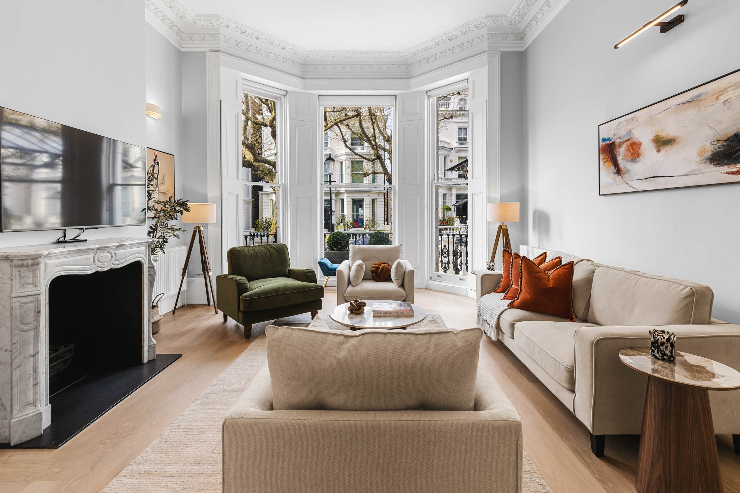 Victorian living room photography in Notting Hill: bay windows, marble fireplace and green velvet armchair