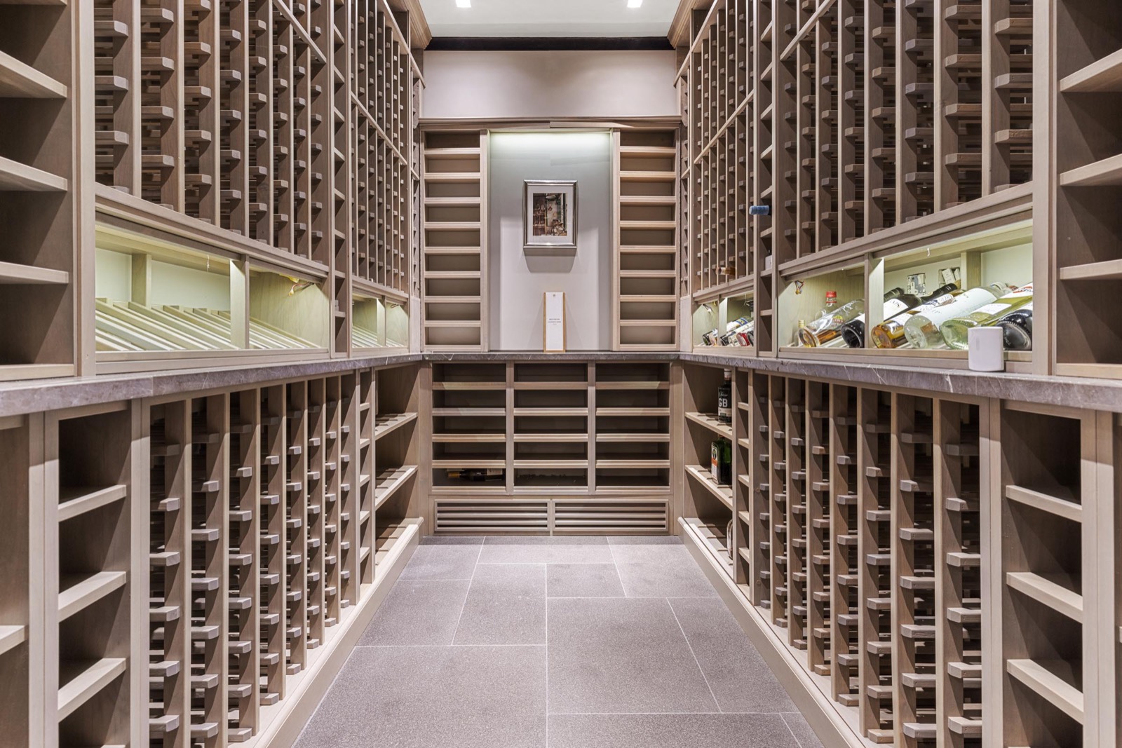 Wine cellar photography in a Knightsbridge home: oak racking, stone floor and soft display lighting